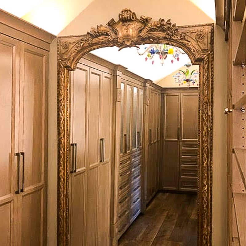 Walk in rust brown closet with closed doors.