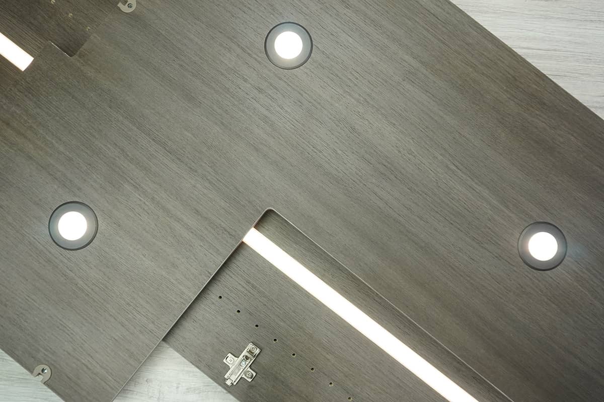 Showroom Luxury grey Walk in Closet with Led lighting, shelves, long hanging and medium hanging with glass doors. In addition an island in the center.