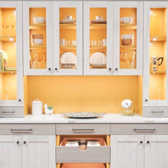 Two toned yellow and grey butler pantry with glass doors and LED lighting