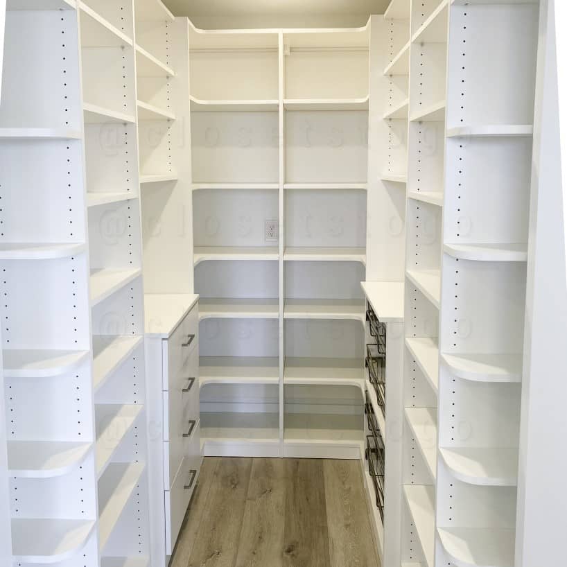 A Luxury White Closet with a medium sized window in the center, several shelves to the left and right of the window. Including some medium hangs.