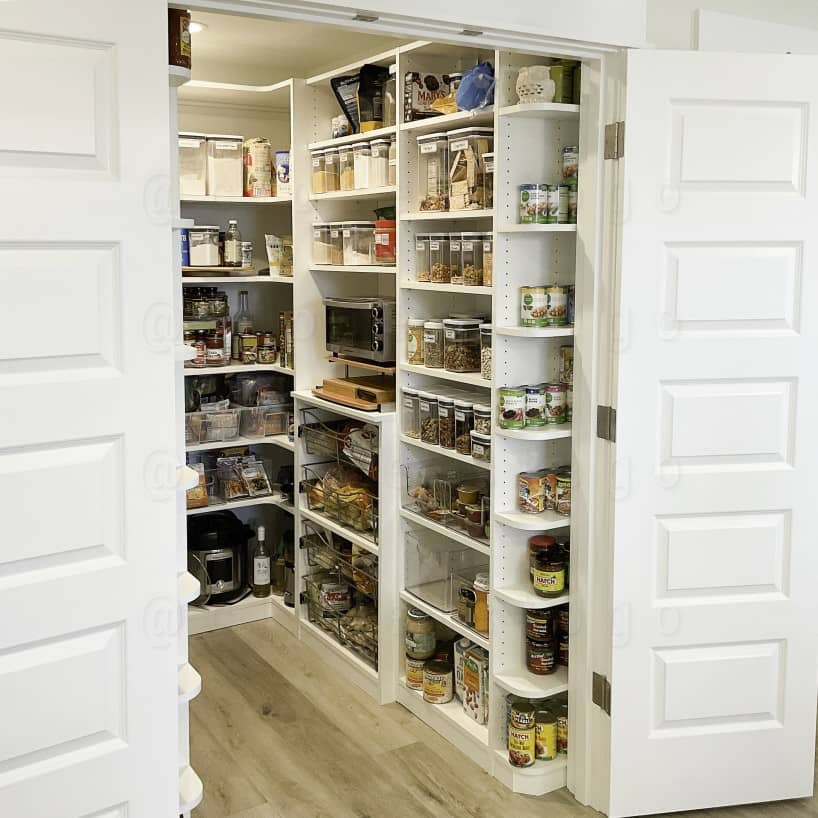 A Luxury White Closet with a island in the center, several drawers and long doors for long hang.