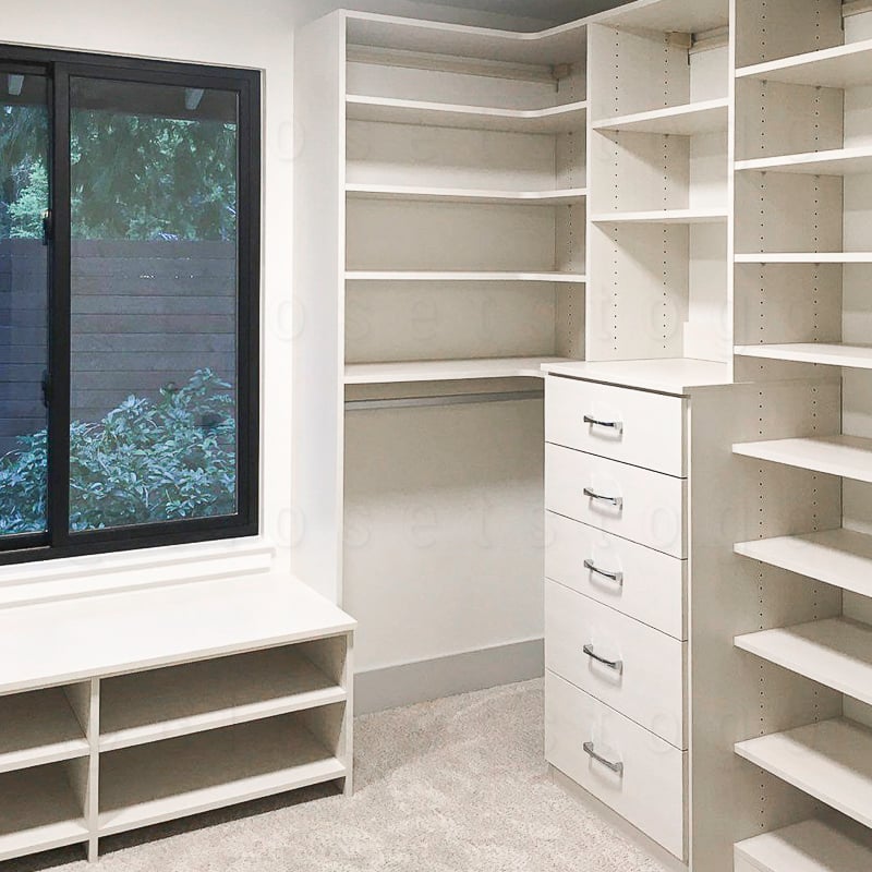 Walk in white closet with an abudant amount of shelves and drawers