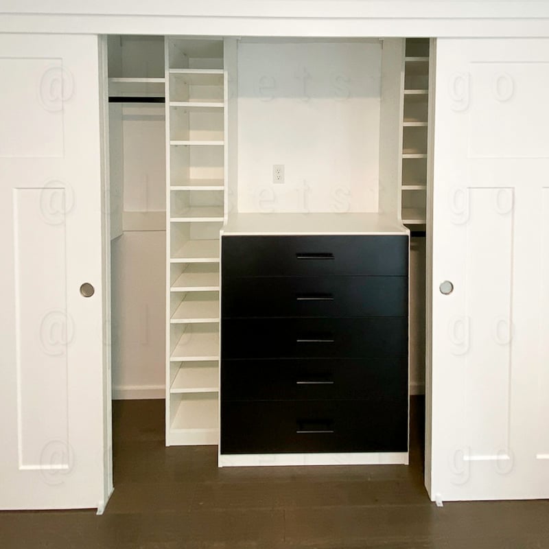 Two toned closet white and black with small shelves.