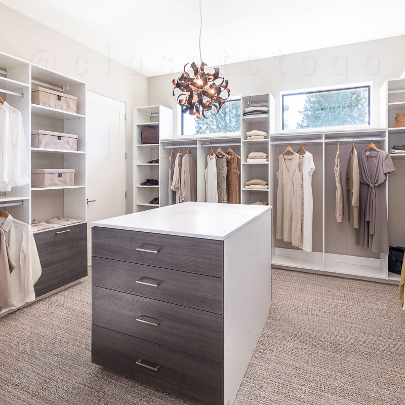 Two toned walk in closet with natural lighting and shelves.
