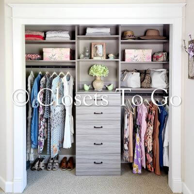 Reach in grey closet with drawers, long hang, medium hang and shelves.