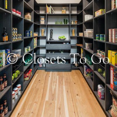 Walk in luxurious black pantry with shelves.
