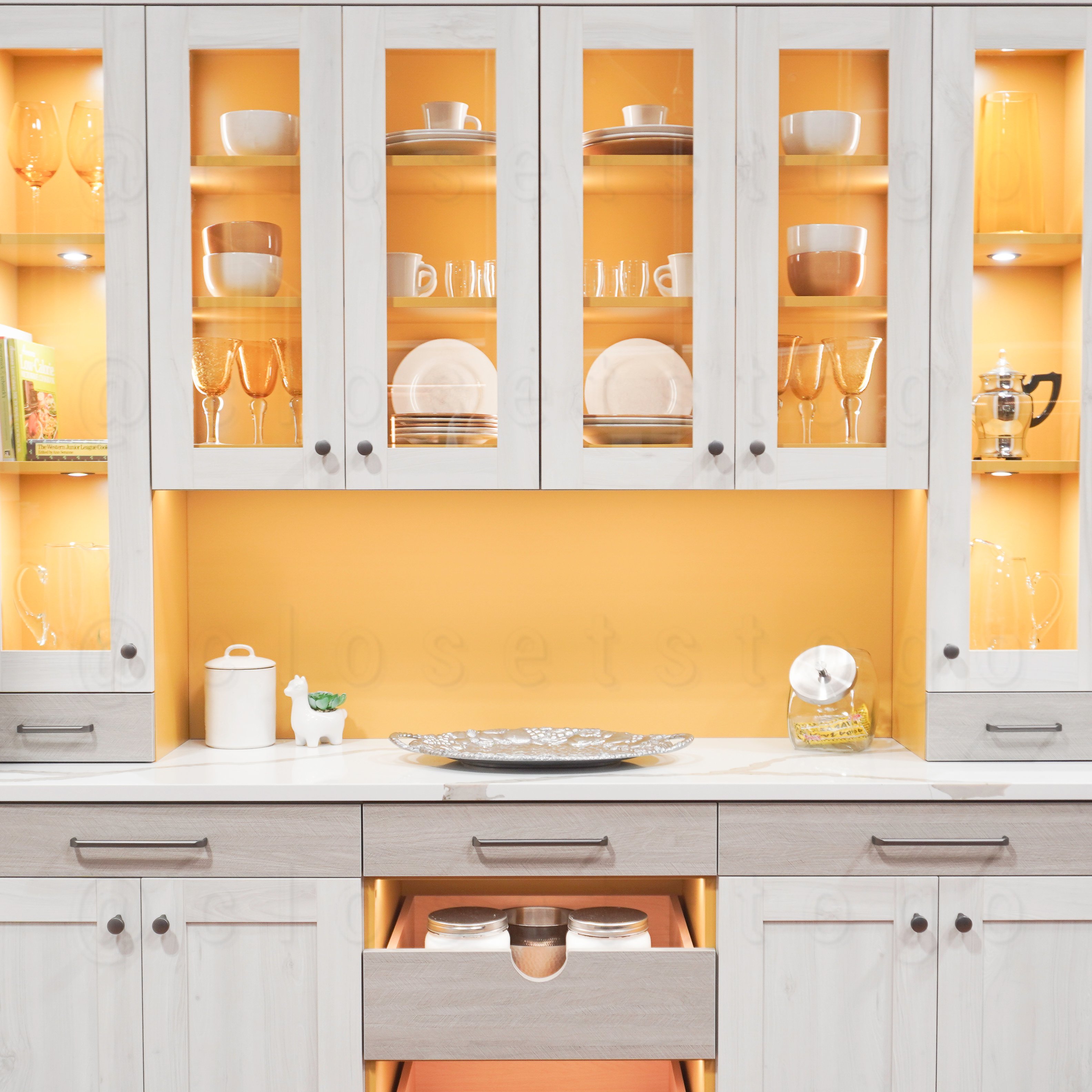 Two toned yellow and grey butler pantry with glass doors and LED lighting